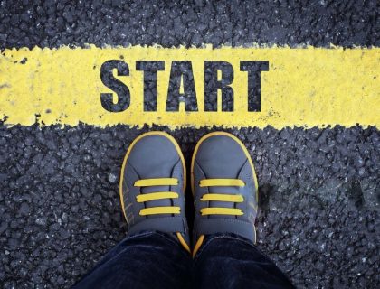 Scarpe di una persona di fronte a una linea di partenza con la scritta START, con testo Come iniziare una Tesi di Laurea Magistrale