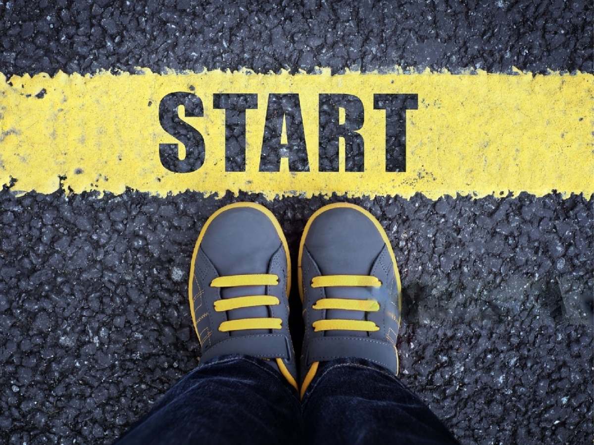 Scarpe di una persona di fronte a una linea di partenza con la scritta START, con testo Come iniziare una Tesi di Laurea Magistrale