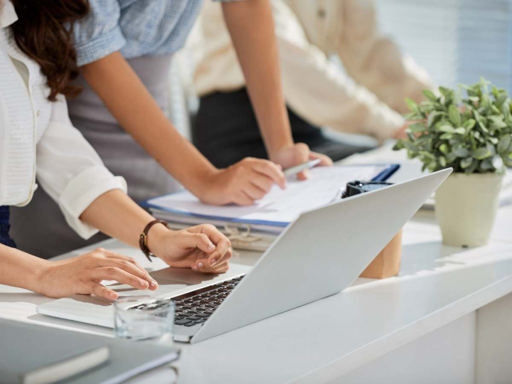 Persone che lavorano su un computer portatile e documenti con testo Indice tesi di master